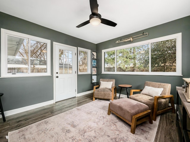 sitting room with ceiling fan, baseboards, and wood finished floors