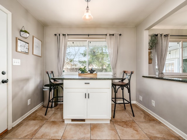 dining room with light tile patterned floors, visible vents, and baseboards