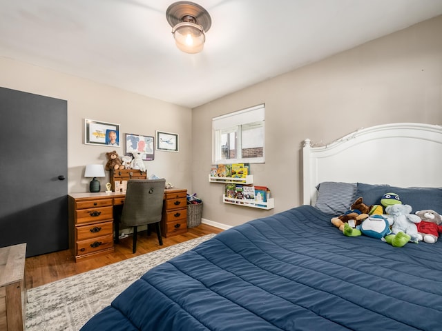 bedroom with baseboards and wood finished floors