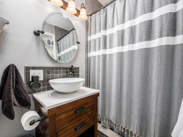 full bath featuring tile walls, vanity, and decorative backsplash