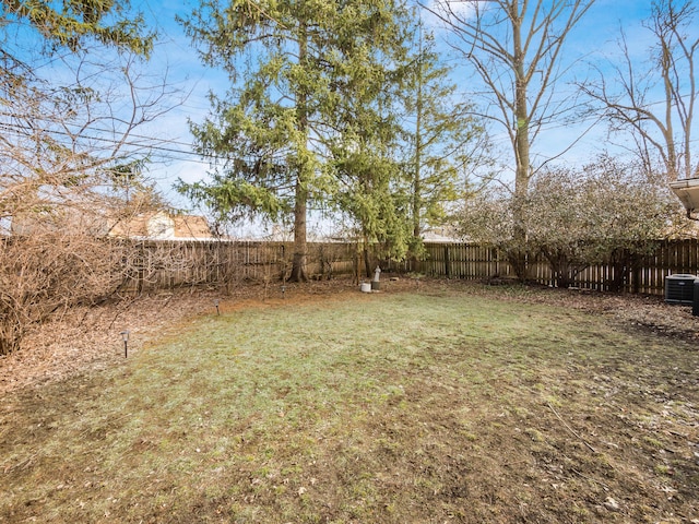 view of yard with a fenced backyard and central AC unit