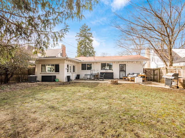 back of property with cooling unit, a fenced backyard, a lawn, a chimney, and a patio area