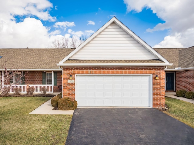 ranch-style house featuring a front yard, driveway, roof with shingles, a garage, and brick siding