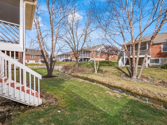 view of yard featuring a residential view and stairs