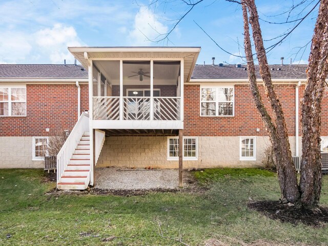 back of house featuring a yard, brick siding, stairs, and a sunroom