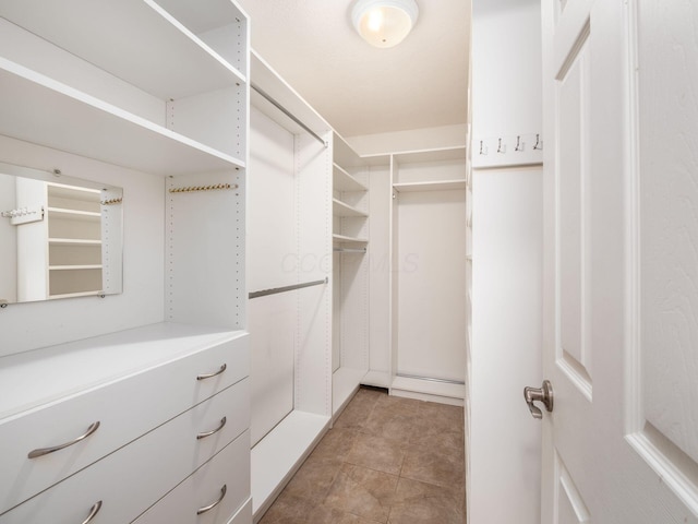 spacious closet with light tile patterned floors