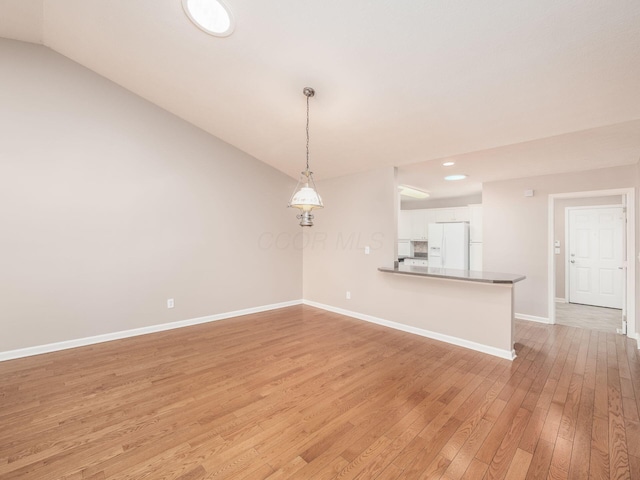 empty room featuring recessed lighting, baseboards, vaulted ceiling, and light wood finished floors