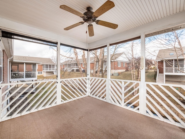 unfurnished sunroom featuring a healthy amount of sunlight and a ceiling fan