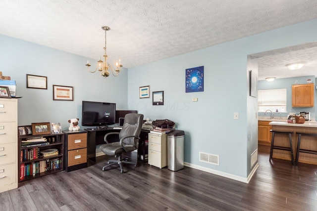 office area with dark wood finished floors, visible vents, a sink, and a textured ceiling