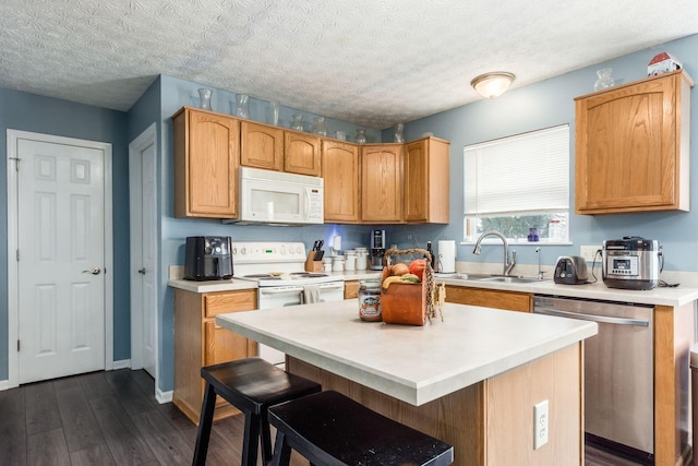 kitchen with white appliances, light countertops, a sink, and dark wood-style flooring