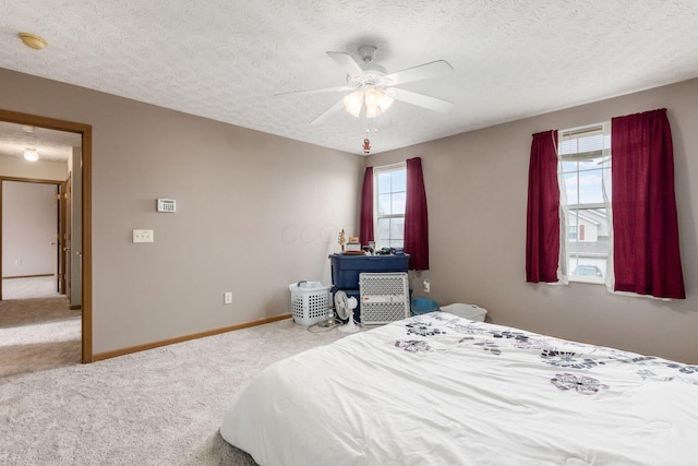 carpeted bedroom featuring a textured ceiling, a ceiling fan, and baseboards