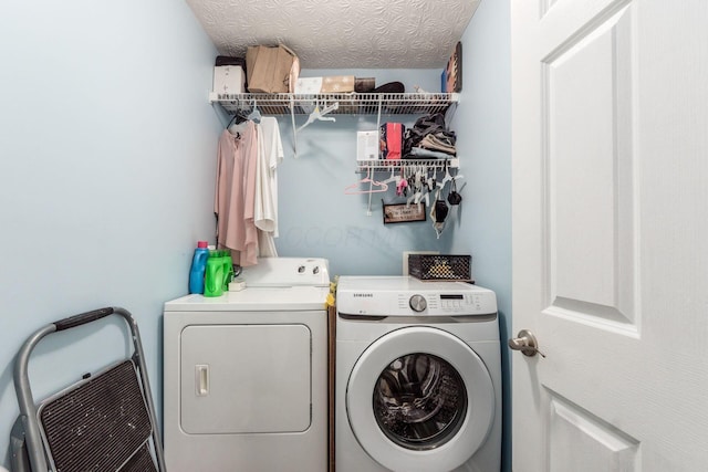 laundry area with laundry area, a textured ceiling, and washing machine and clothes dryer