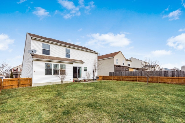 rear view of property with a fenced backyard and a lawn