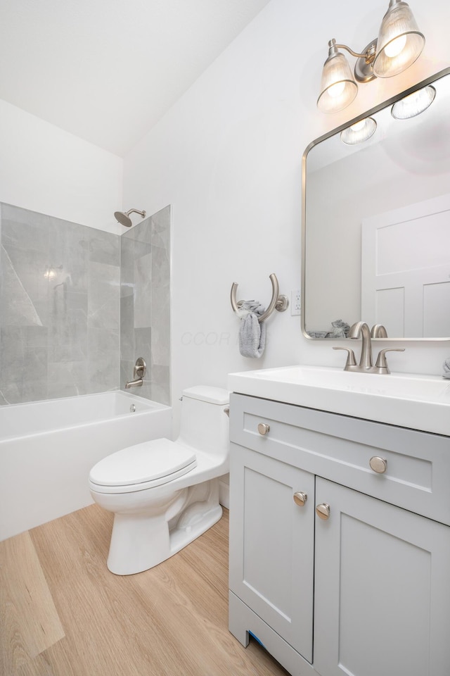 full bathroom featuring vanity, bathing tub / shower combination, wood finished floors, and toilet