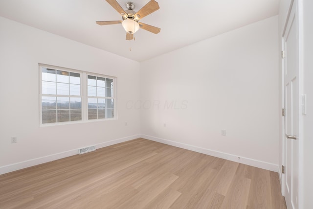 unfurnished room featuring light wood finished floors, a ceiling fan, visible vents, and baseboards