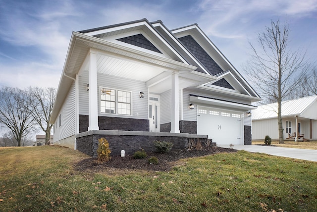 craftsman-style house featuring driveway, stone siding, and a front lawn