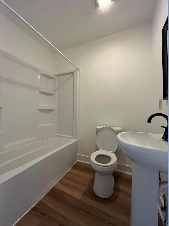 full bathroom featuring toilet, shower / bathing tub combination, baseboards, and wood finished floors