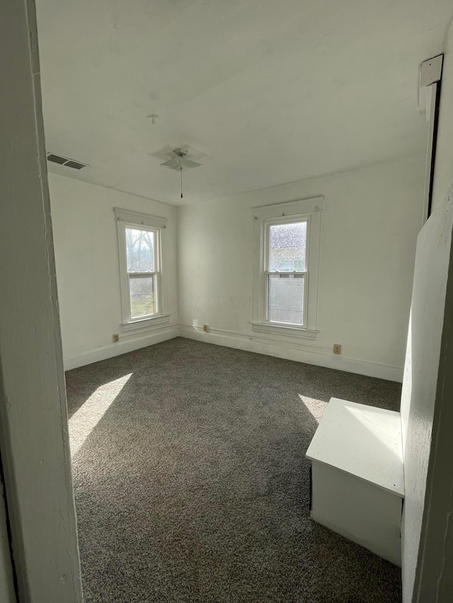 spare room featuring visible vents, baseboards, carpet, and a ceiling fan