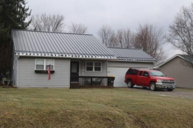 view of front of house with a garage, metal roof, a standing seam roof, and a front yard