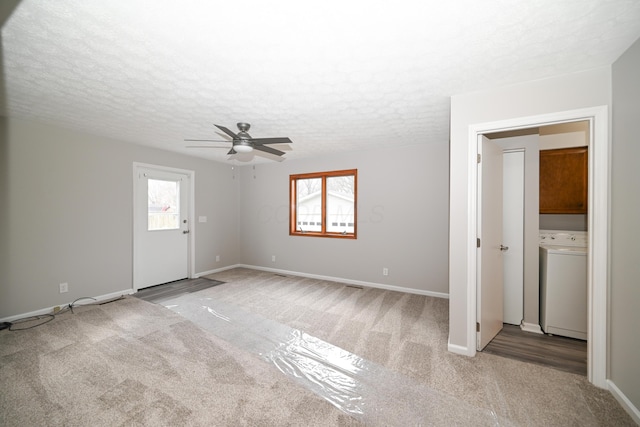 unfurnished room featuring plenty of natural light, washer / clothes dryer, and carpet flooring