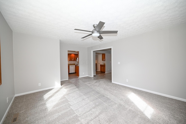 carpeted spare room with a ceiling fan, a textured ceiling, and baseboards