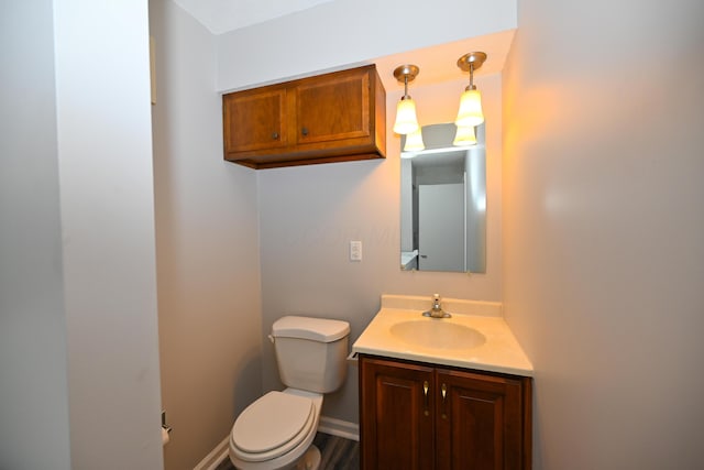 bathroom with toilet, baseboards, and vanity