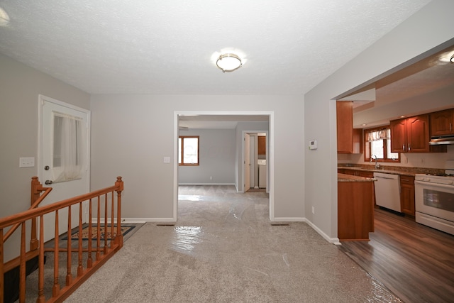 corridor with a textured ceiling, a sink, an upstairs landing, and baseboards