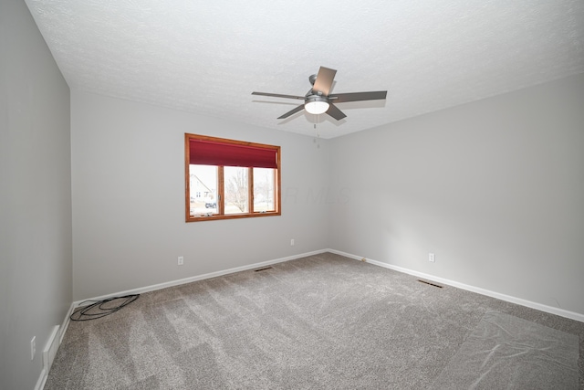 spare room with carpet floors, ceiling fan, a textured ceiling, and baseboards