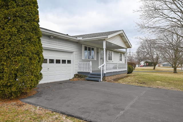 ranch-style home with covered porch, driveway, a front yard, and a garage