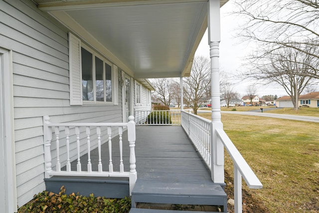 wooden deck with a yard and a porch