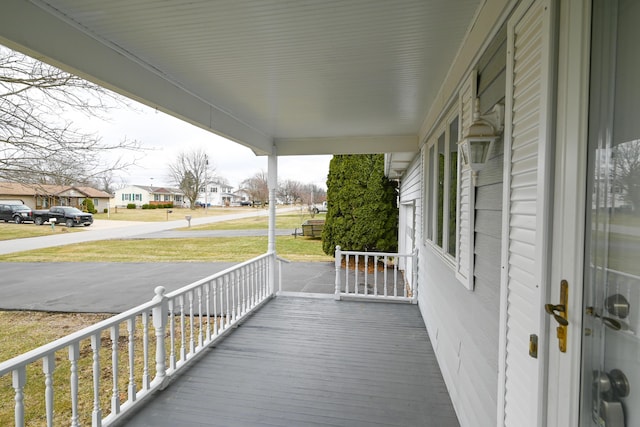 deck featuring covered porch and a residential view