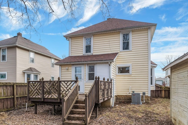 back of property with roof with shingles, cooling unit, a wooden deck, and fence