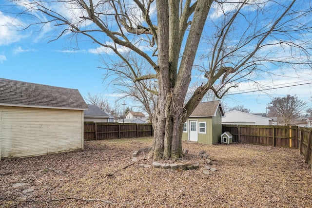 view of yard with a fenced backyard, a storage unit, and an outdoor structure