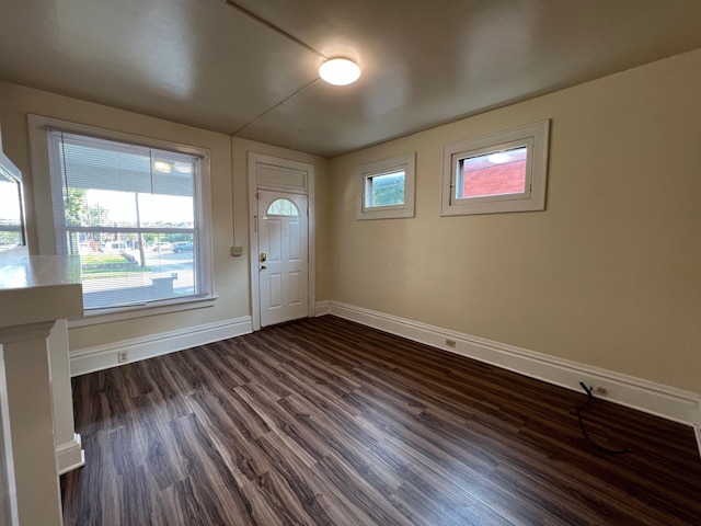 entrance foyer with dark wood-style flooring and baseboards