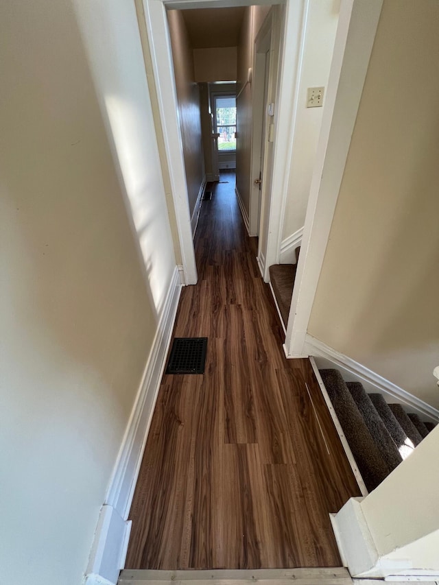 hallway featuring visible vents, stairway, baseboards, and wood finished floors