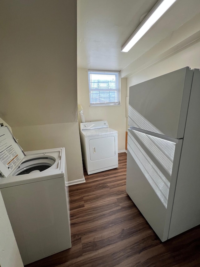 laundry area with baseboards, dark wood finished floors, and washing machine and clothes dryer