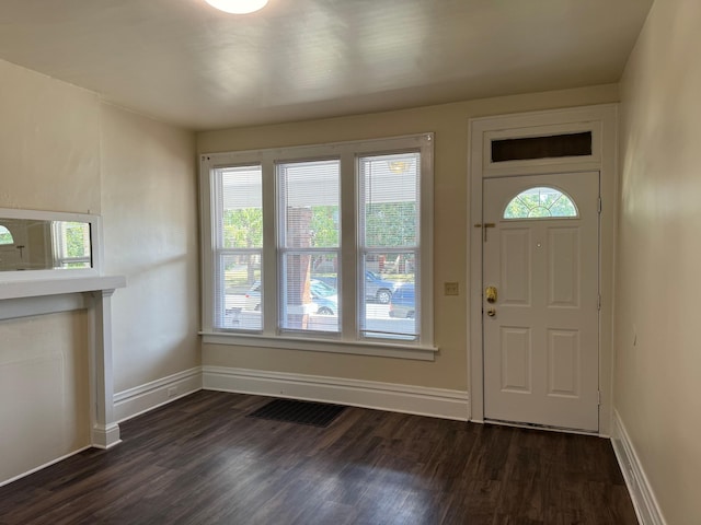 foyer entrance with visible vents, baseboards, and dark wood-type flooring