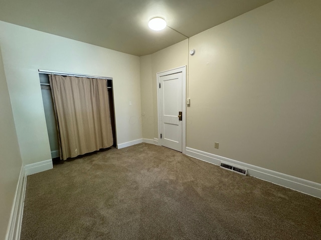 carpeted spare room featuring baseboards and visible vents