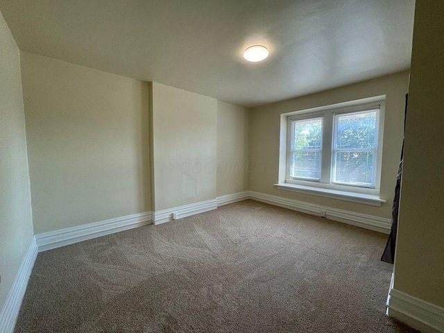 carpeted spare room with baseboards