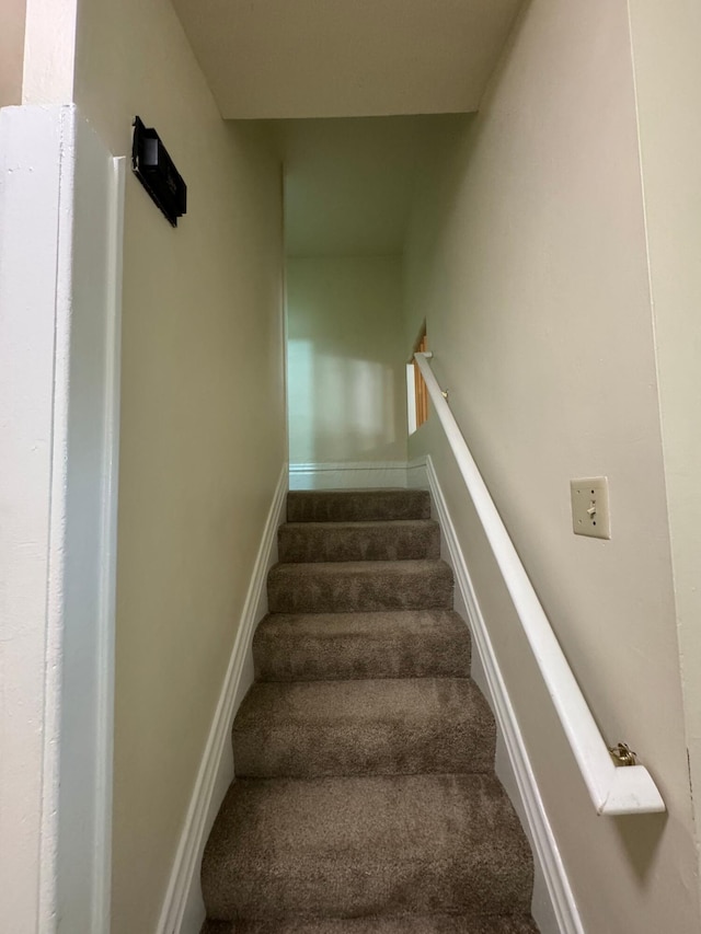 stairway featuring carpet floors and baseboards