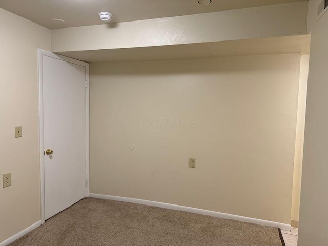 interior space featuring baseboards and light colored carpet