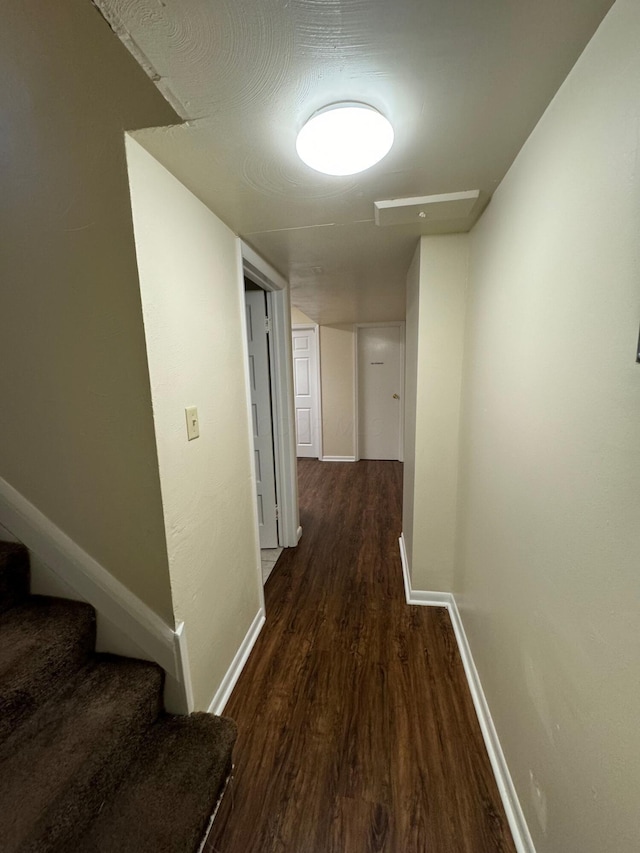 corridor with stairs, baseboards, and wood finished floors