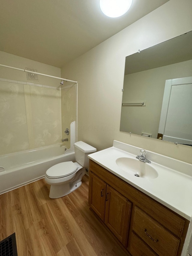 full bath with bathing tub / shower combination, visible vents, toilet, vanity, and wood finished floors