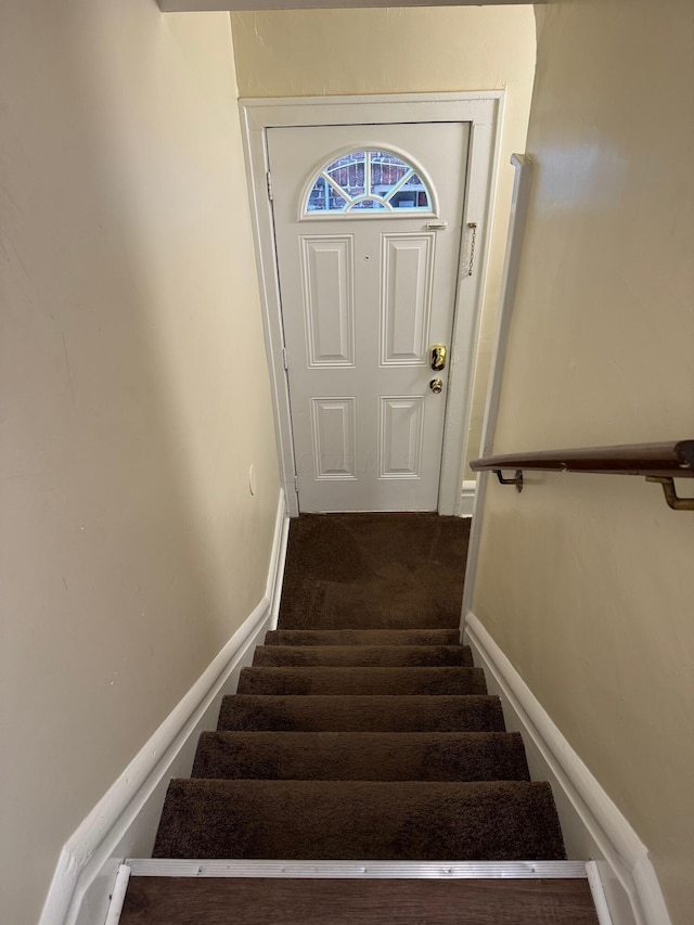 stairs featuring baseboards and carpet flooring