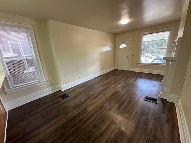 foyer featuring dark wood-style floors, baseboards, and visible vents