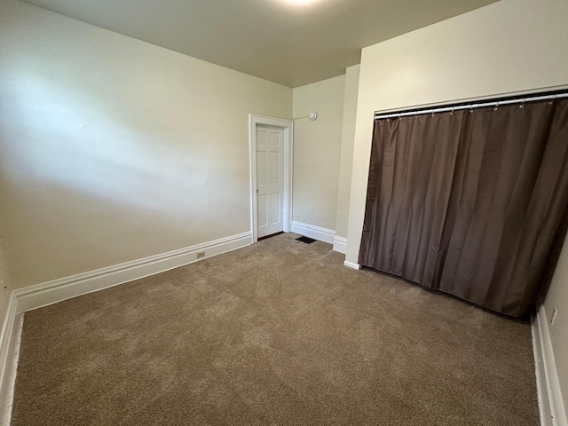 unfurnished bedroom with a closet, baseboards, and carpet flooring