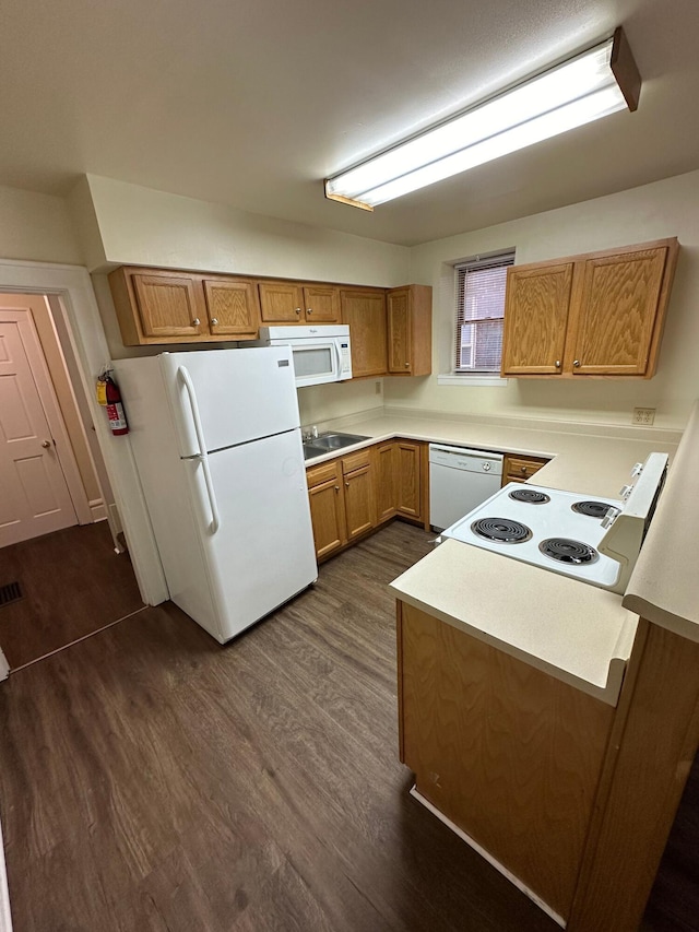 kitchen with dark wood-style floors, light countertops, white appliances, and brown cabinetry