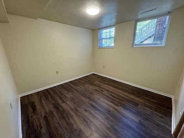 interior space featuring dark wood finished floors, visible vents, and baseboards