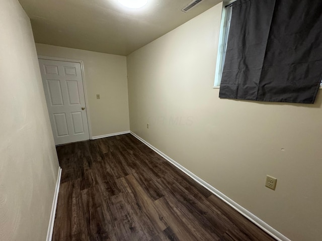 interior space with dark wood-style floors, visible vents, and baseboards