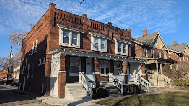 view of front of home with a porch and brick siding